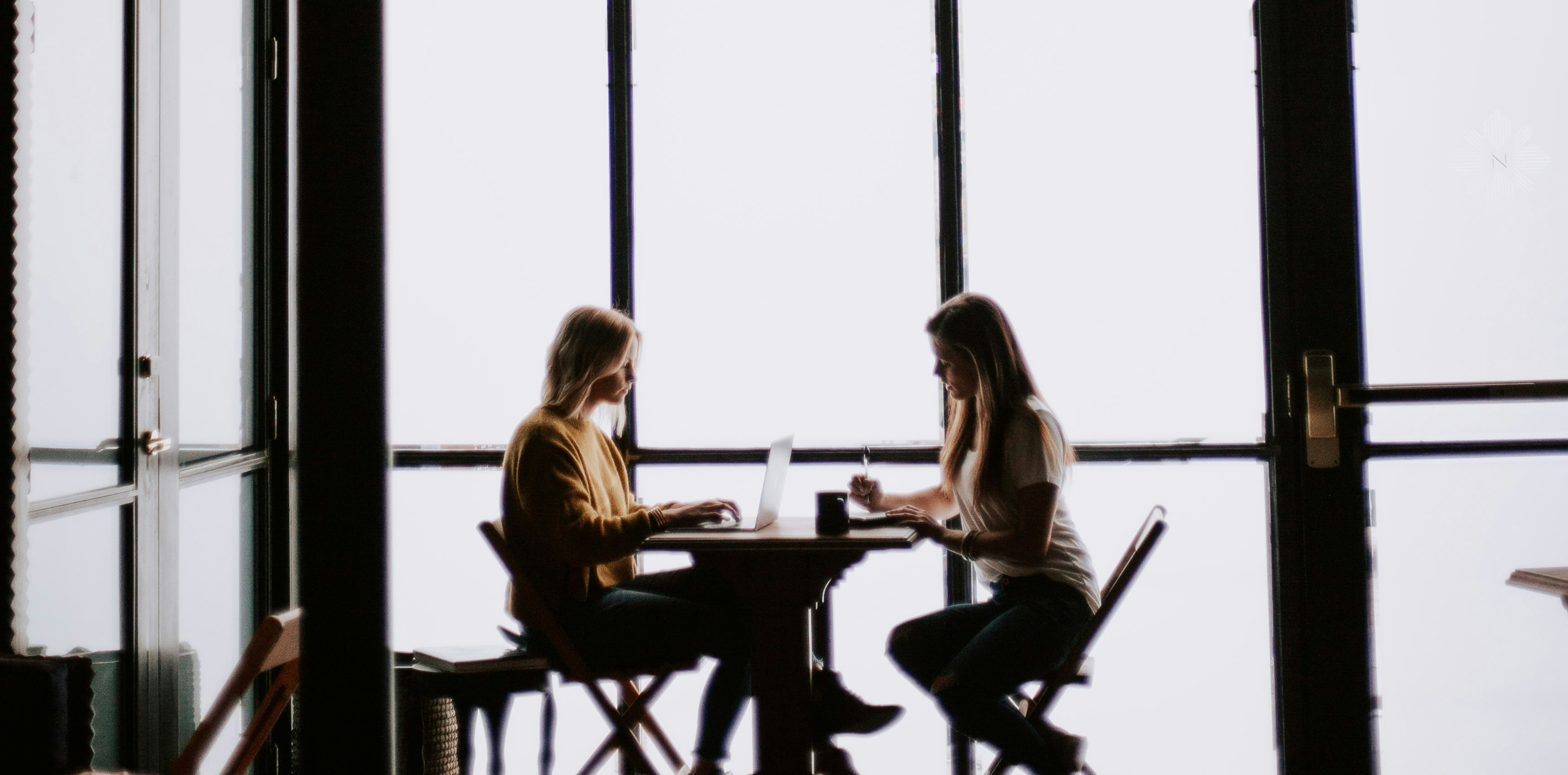 TwoMedia team collaborating by a bright window.